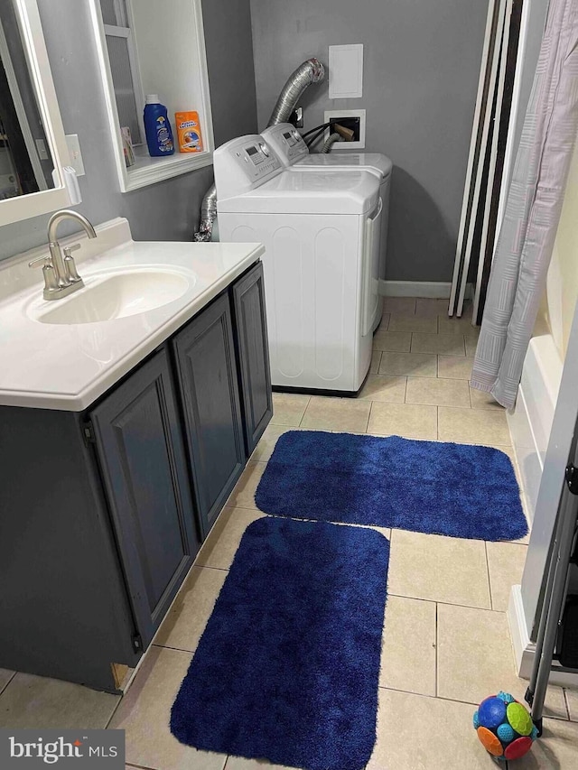 laundry area featuring sink, separate washer and dryer, and light tile patterned floors