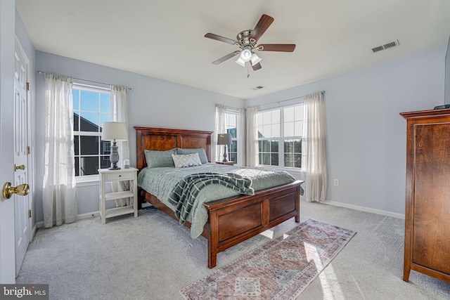 carpeted bedroom featuring multiple windows and ceiling fan