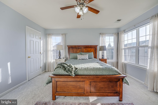 carpeted bedroom featuring ceiling fan and multiple windows