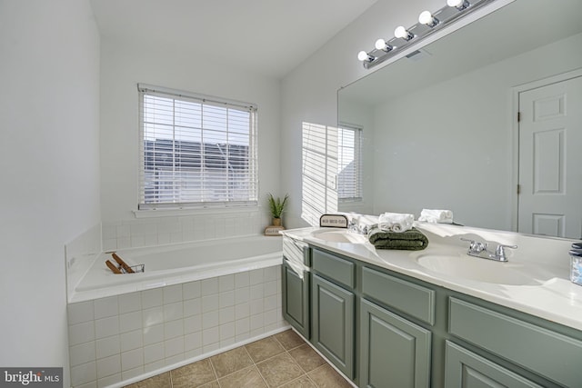 bathroom featuring vanity, tile patterned floors, and tiled bath