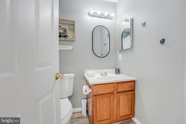 bathroom featuring vanity, hardwood / wood-style flooring, and toilet