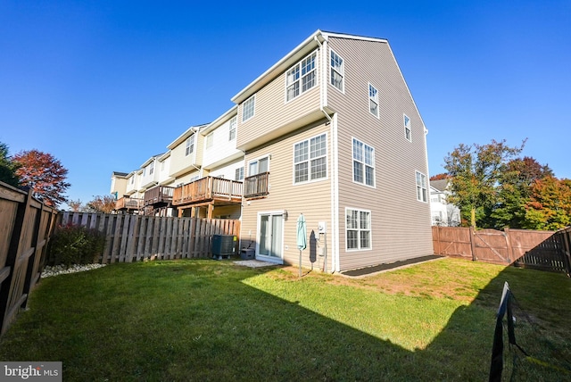 back of property with central AC and a lawn