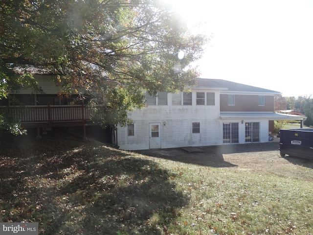 rear view of property featuring a patio area, a deck, and a lawn