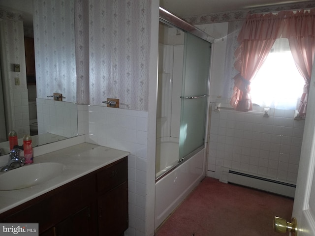 bathroom featuring vanity, a baseboard heating unit, and bath / shower combo with glass door