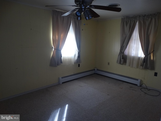 unfurnished room featuring ceiling fan and a baseboard heating unit