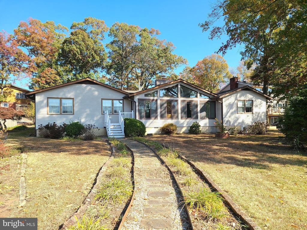 view of front of property with a sunroom and a front yard