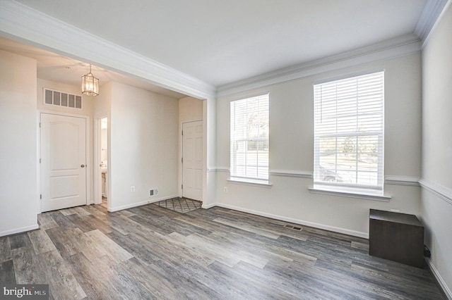 unfurnished room with ornamental molding, an inviting chandelier, and dark hardwood / wood-style floors