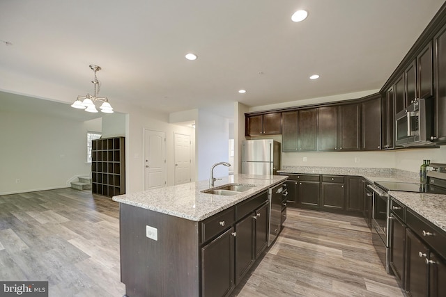 kitchen with light hardwood / wood-style flooring, a center island with sink, stainless steel appliances, and sink