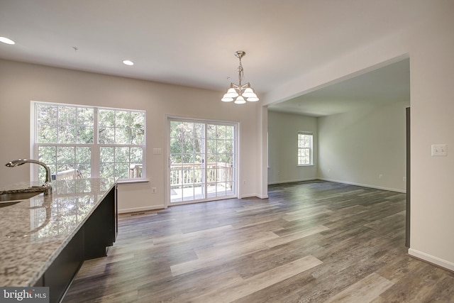 unfurnished dining area with a notable chandelier, dark hardwood / wood-style floors, and sink