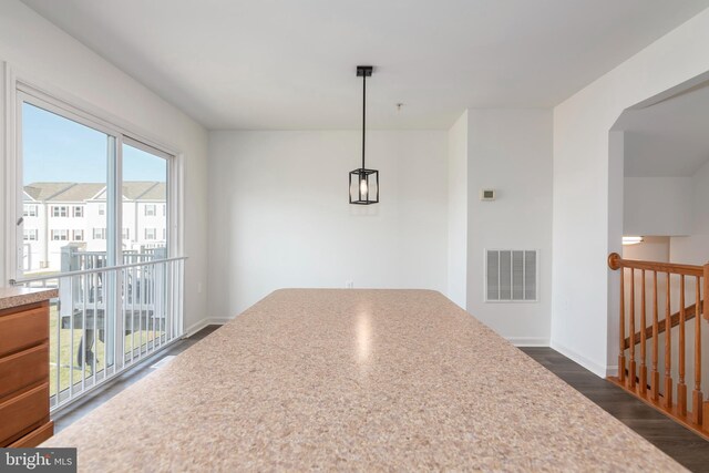 unfurnished dining area with dark wood-type flooring