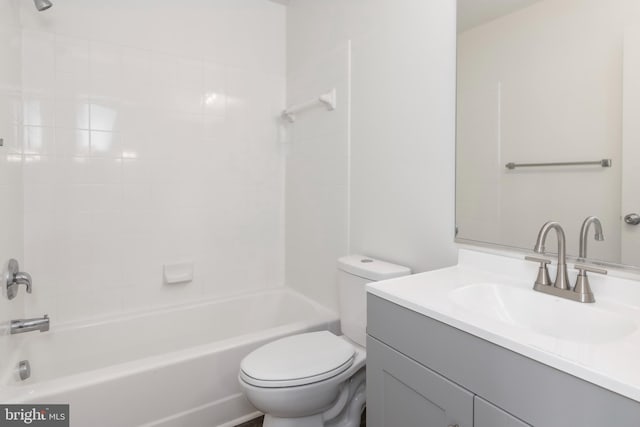 full bathroom featuring tiled shower / bath, vanity, and toilet