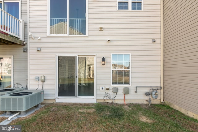 back of house with a yard and central air condition unit