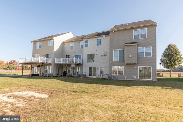 back of house with a balcony and a yard