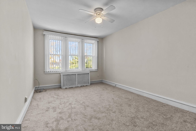 unfurnished room featuring light carpet, radiator heating unit, and ceiling fan