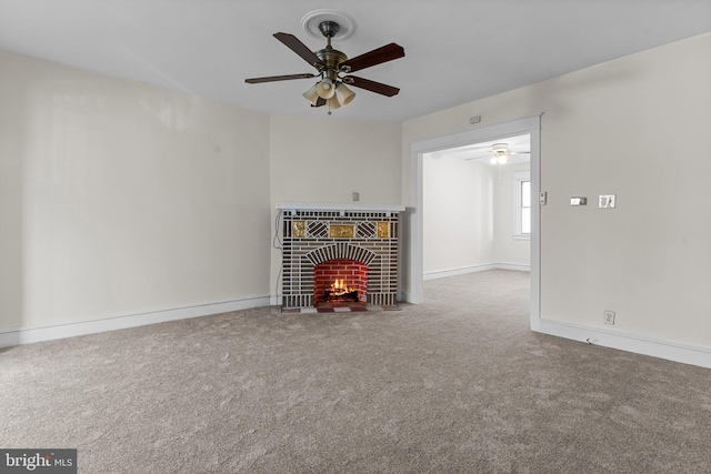 unfurnished living room featuring ceiling fan, carpet flooring, and a brick fireplace