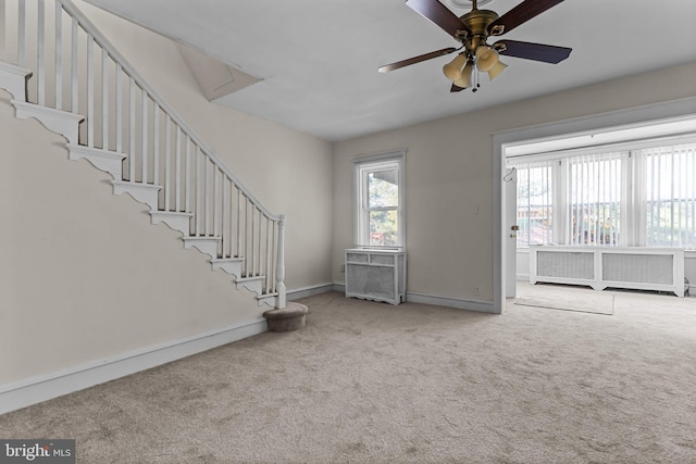 unfurnished living room featuring ceiling fan and carpet floors