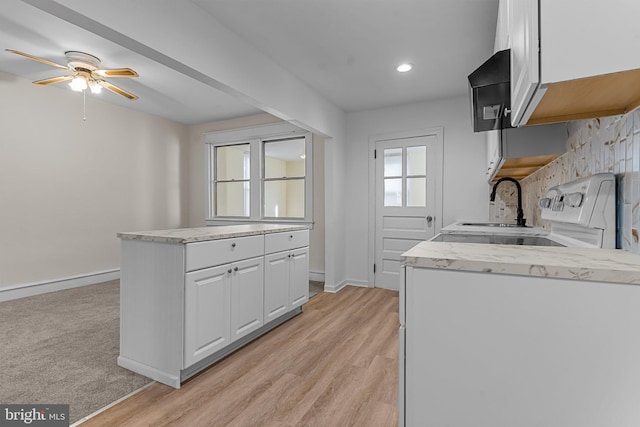 kitchen with sink, white cabinetry, light hardwood / wood-style floors, and ceiling fan