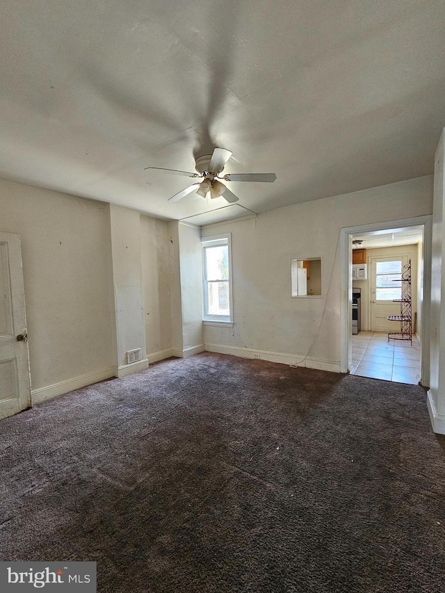 carpeted spare room featuring ceiling fan and a healthy amount of sunlight