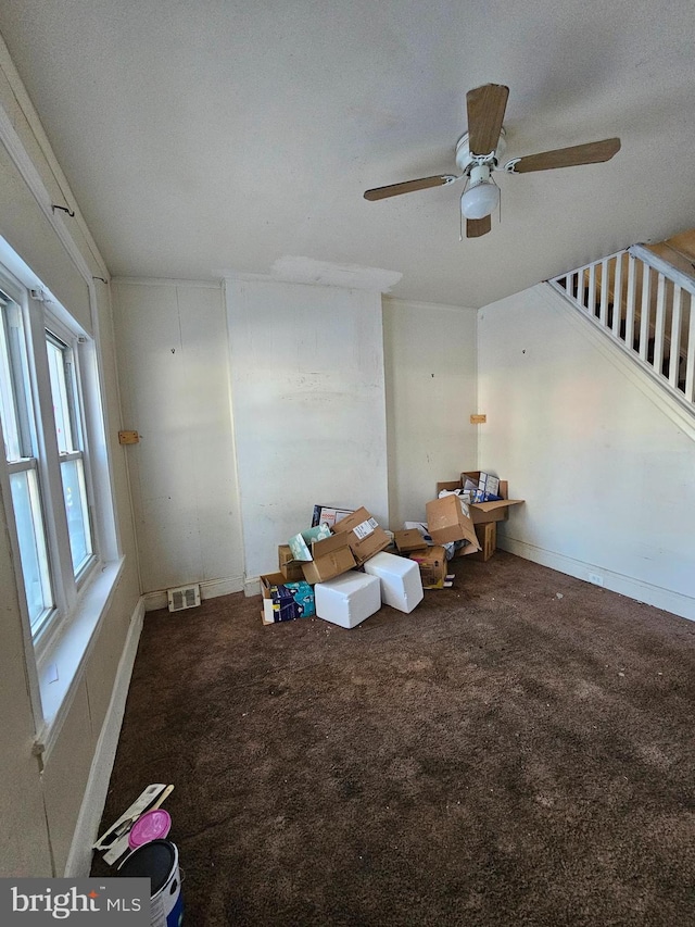 unfurnished living room with a textured ceiling, ceiling fan, and carpet flooring