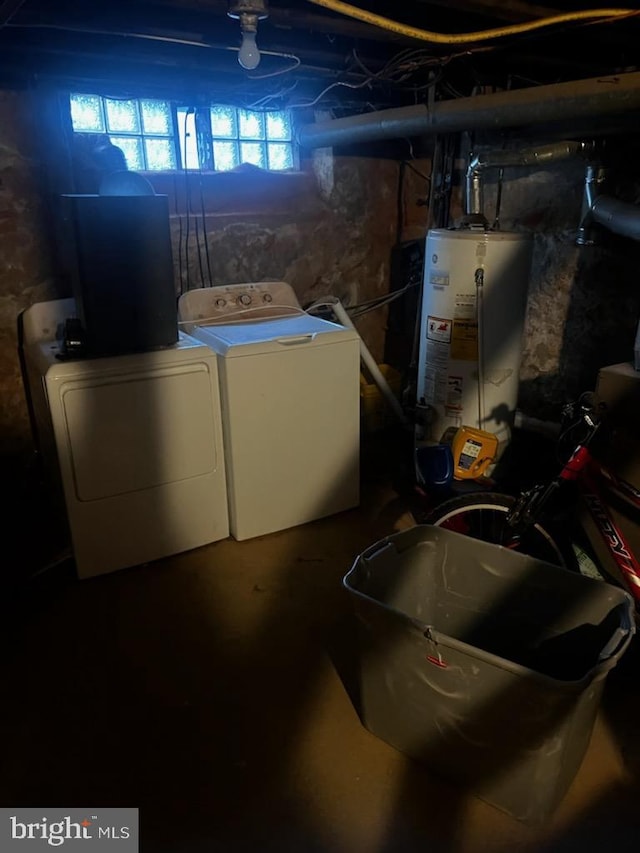 clothes washing area with water heater and independent washer and dryer