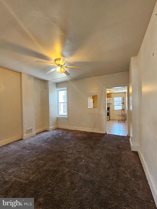 empty room featuring ceiling fan and light carpet