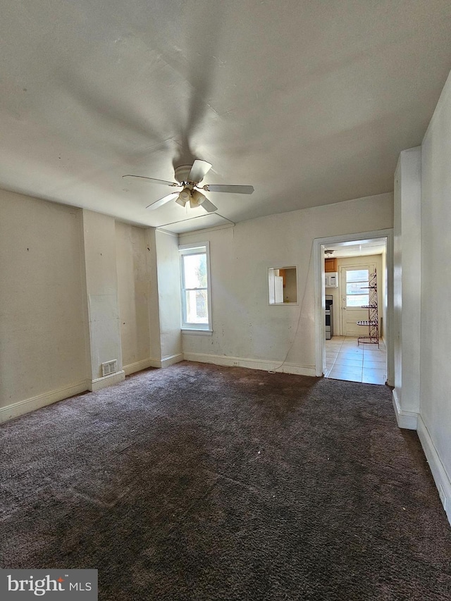 unfurnished room featuring ceiling fan, light colored carpet, and a wealth of natural light