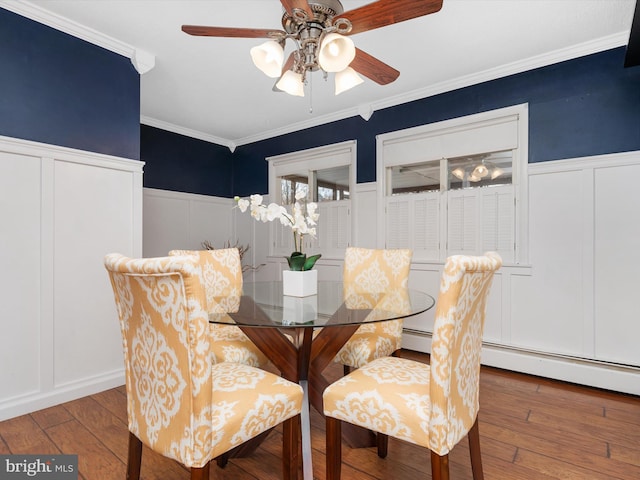 dining space with hardwood / wood-style floors, ceiling fan, and ornamental molding