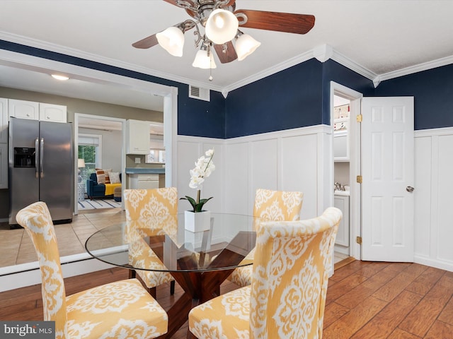 dining area with light hardwood / wood-style flooring, ceiling fan, and crown molding