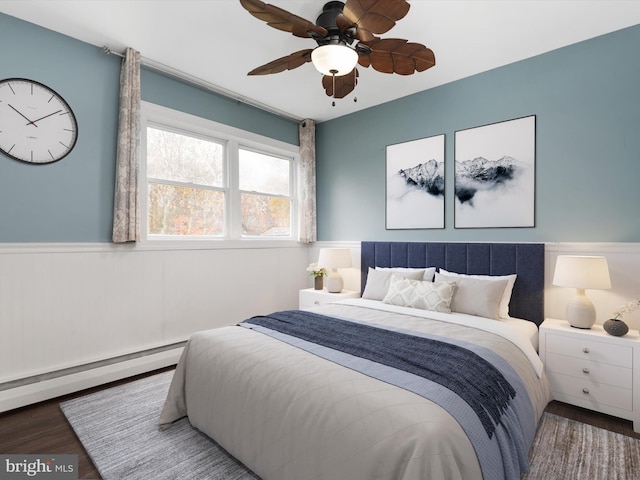 bedroom featuring hardwood / wood-style floors, ceiling fan, and a baseboard radiator