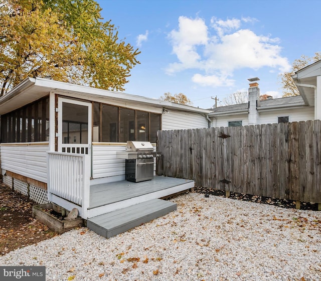 view of home's exterior with a wooden deck and a sunroom