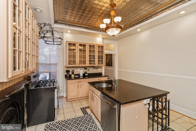 kitchen featuring a kitchen island with sink, light brown cabinets, stainless steel appliances, sink, and an inviting chandelier