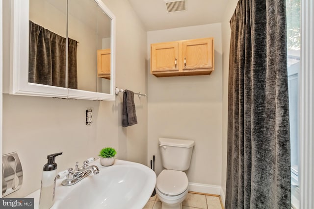 bathroom featuring toilet, sink, tile patterned flooring, and a shower with curtain