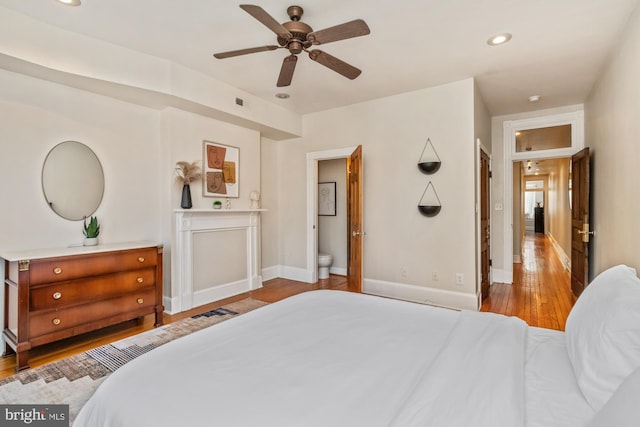 bedroom featuring light hardwood / wood-style floors, ensuite bathroom, and ceiling fan