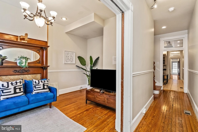 living room with hardwood / wood-style flooring and an inviting chandelier