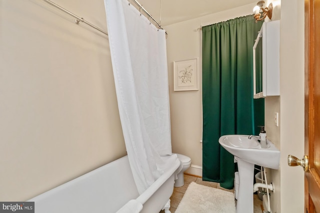 bathroom featuring toilet, shower / tub combo, and tile patterned flooring