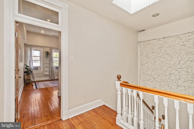 corridor featuring hardwood / wood-style floors and a skylight