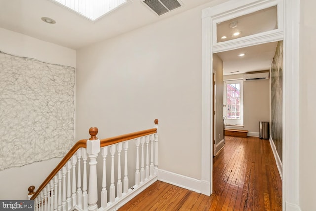 hall featuring hardwood / wood-style floors and a wall mounted air conditioner