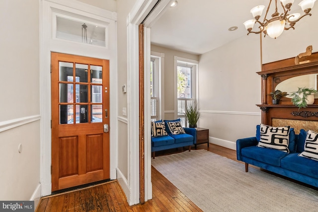 entrance foyer with dark wood-type flooring and an inviting chandelier