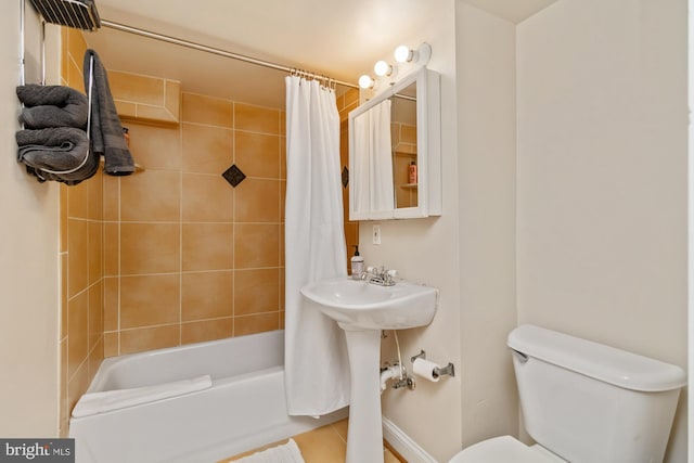 bathroom featuring shower / bath combo with shower curtain, toilet, and tile patterned flooring