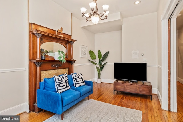 living area with hardwood / wood-style floors and an inviting chandelier