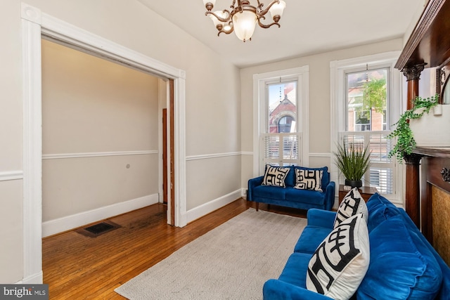 living area with hardwood / wood-style flooring and a chandelier