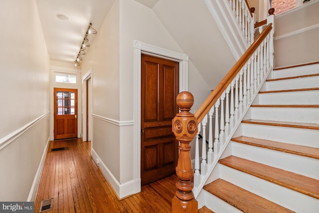 entrance foyer featuring lofted ceiling, track lighting, and hardwood / wood-style flooring