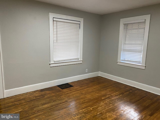 empty room with dark hardwood / wood-style flooring