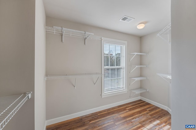 spacious closet featuring wood finished floors and visible vents