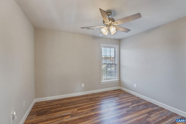 spare room with dark wood-style floors, ceiling fan, and baseboards