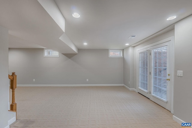 below grade area featuring visible vents, recessed lighting, light colored carpet, and baseboards