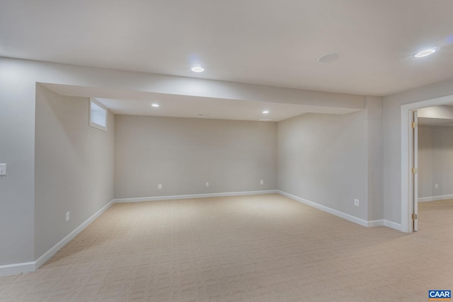 finished below grade area with light carpet, baseboards, and recessed lighting