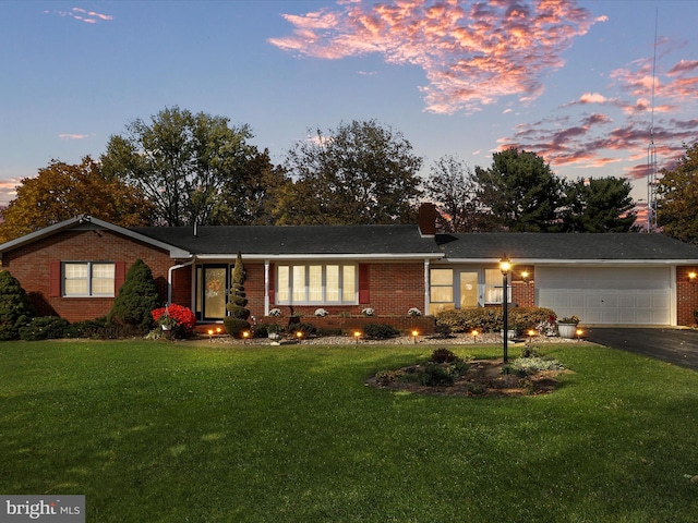 ranch-style house with a lawn and a garage