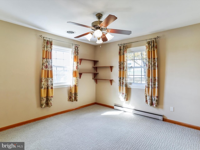 empty room with ceiling fan, carpet flooring, and a baseboard heating unit