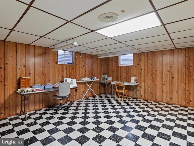 office space featuring a drop ceiling and wooden walls